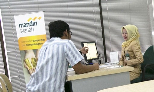 A bank officer talks to a customer at a Bank Syariah Mandiri branch in Central Jakarta.