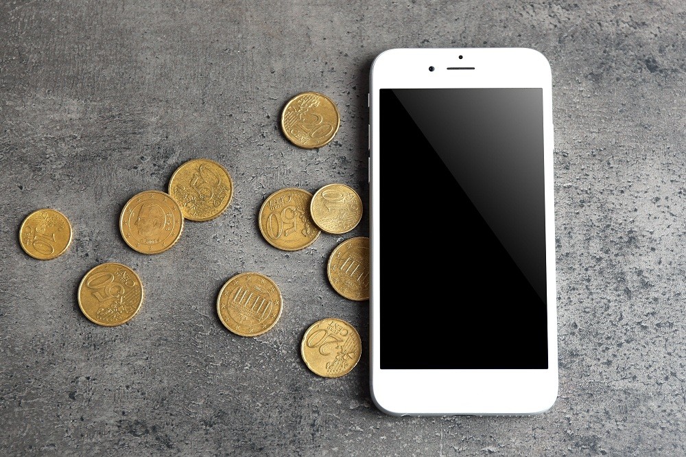 Mobile phone and money on grey background. A prisoner in Kosovo had swallowed an entire mobile phone.