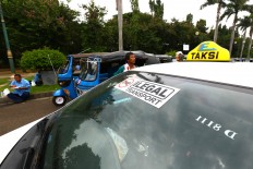 Thousands of Jakarta Taxi units parked at Monument Nasional (Monas) while the drivers protest against ride-hailing app in front of the Istana Merdeka, Jakarta, Monday (03/14/2016). During the action they demanded the closure of application service company like Uber, Grab and Gojek. Their presence are illegal as transportation public operating because they have no license as it and have contributed to the decrease of the conventional transportation drivers'income .