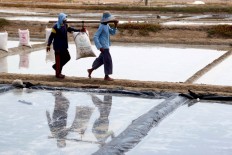 The working man brings a sack of raw salt from fields to the warehouse  