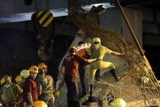 Rescue workers clear the rubbles of a partially collapsed overpass in Kolkata, India,Thursday, March 31, 2016. A long section of a road overpass under construction collapsed Wednesday in a crowded Kolkata neighborhood, with tons of concrete and steel slamming into midday traffic, killing several and injuring many. 