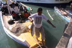 A fisherman carries a catch from the boat to be sold at the Fish Landing Base in Gorontalo city. JP/Syamsul Huda M. Suhari


