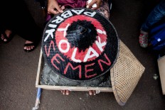 A Srikandi Kendeng protestor displays a hat painted with a message rejecting the planned cement factory. The Jakarta Post/Seto Wardhana