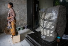 One of the women stands beside a stone monument at the Jakarta LBH office. The Jakarta Post/Seto Wardhana