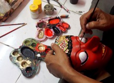 The process of mask masking ist The process of mask masking begins by choosing the wood, carving the mask and then adding decorations. JP/ Ganug Nugroho Adi