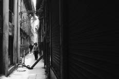 A man walks on the side of a building sustained by a log to prevent it from collapsing. Kathmandu, May 1, 2015. JP/ Ayomi Amindoni

 