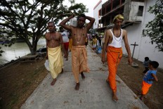 A Hindu priest leads followers to the location of the Panguni Uthiram ritual by the riverside. JP/ Hotli Simanjuntak
