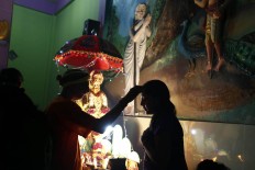 A Hindu devotee receives a blessing from the temple priest before the Panguni Uthiram procession. JP/Hotli Simanjuntak
