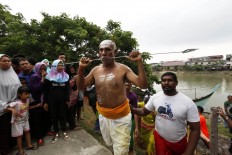 A devotee pierces his cheeks in the Panguni Uthiram ritual, as an expression of the suffering of Lord Murugan while battling against evil. JP/ Hotli Simanjuntak