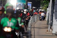 Alfini walks on the sidewalk at Jalan Sudirman Jakarta while a group of motorcycles attempting to avoid traffic by trespassing on a sidewalk on Monday. She took action to protest unruly bikers. The Jakarta Post/ Dhoni Setiawan