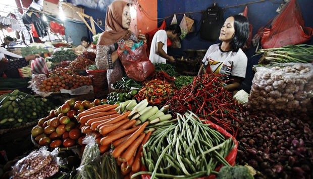 A woman buys vegetables at a stall in a traditional market in Jakarta.