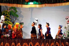 Puppeteer Tantan Sugandi, helped by his students, plays various puppet characters picturing the real life of people in a village as a part of series of events at the Gunungan International Mask and Puppets Festival. [JP/Arya Dipa]