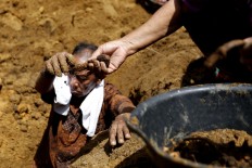 Family members carefully collect all their ancestors’ bones. They have to separate bone parts and dirt as the ancestors have been buried for decades, or even centuries. Sometimes, they cannot find all the bones. JP/ Hotli Simanjuntak
