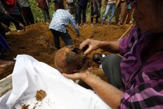 Bones are cleaned in preparation for being placed into a small box for storage at the monument. JP/ Hotli Simanjuntak