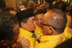 Newly elected Golkar Party chairman Setya Novanto (center) hugs rival Ade Komarudin (left) and outgoing chairman Aburizal Bakrie (right) following the announcement that Setya won the vote. JP/Zul Trio Anggono