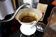 A barista shows how to serve a cup of coffee while explaining that the technique used to pour hot water onto the coffee grains determines the quality of the coffee flavor. JP/ Hotli Simanjuntak