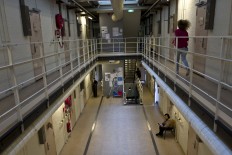 In this Tuesday, April 26, 2016 photo, a migrant sits outside her room while another runs in the corridor of the women section of  the former prison of De Koepel in Haarlem, Netherlands. With crime declining in the Netherlands, the country is looking at new ways to fill its prisons. AP Photo/Muhammed Muheisen
