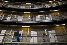 In this Sunday, May 1, 2016 photo, an Afghan refugee man, center, listens to another Afghan refugee at the former prison of De Koepel in Haarlem, Netherlands. The Dutch government has let Belgium and Norway put prisoners in its empty cells and now, amid the huge flow of migrants into Europe, several Dutch prisons have been temporarily pressed into service as asylum seeker centers. AP Photo/Muhammed Muheisen