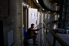 In this Sunday, May 1, 2016 photo, Afghan refugee Siratullah Hayatullah, 23, drinks tea by the doorway of his room at the former prison of De Koepel in Haarlem, Netherlands.  AP Photo/Muhammed Muheisen

