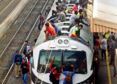 Passengers sit on the roof of a train at Cawang Station in East Jakarta on April 3, 2014. JP/Ricky Yudhistira