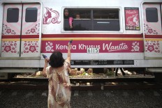 A female passenger purchases a bottle of water from a vendor on June 16, 2015. JP/Dhoni Setiawan