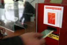 A passenger collects a ticket from the e-ticketing machine at Manggarai Station on July 1, 2013. JP/P.J. Leo