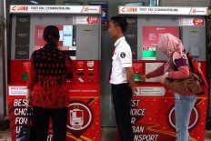 Commuters buy tickets at Sudirman station on Jan. 10, 2015, as a KRL Commuter Line officer looks on. JP/Seto Wardhana