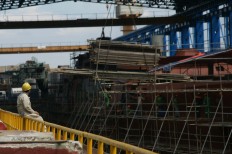A worker observes a 10514 PKR as other staff operate a crane in Semarang, Central Java, on April 4. JP/Wahyoe Boediwardhana