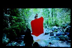 A spectator watches a video at the ARTJOG 2016 event at the Jogja National Museum on Sunday.