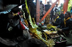 Several shaman pray after placing the offerings next to the sugar mills. JP/Ganug Nugroho Adi