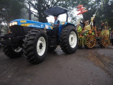 A teenage couple carry sugarcane couple effigies on a cart drawn by a tractor to join the Cembengan parade. JP/Ganug Nugroho Adi