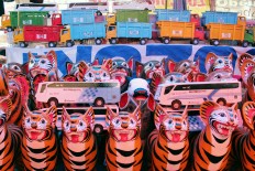 A clay piggy bank and wooden car toys are on display during the Cembengan night market. JP/ Ganug Nugroho Adi