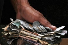 A resident collects money from family members and relatives to be given to the cemetery caretaker to maintain the cemetery’s cleanliness and tidiness.  The Jakarta Post/ Albertus Magnus Kus Hendratmo