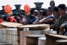 Residents join a mass prayer to pay their respects to their ancestors buried at the cemetery.  The Jakarta Post/ Albertus Magnus Kus Hendratmo