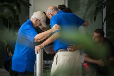 People grieve outside a Hampton Inn & Suites hotel, which turned into a hub for families and friends waiting to hear about loved ones because of its proximity to the Orlando Regional Medical Center, in the wake of a mass shooting that took place the prior night in Orlando, Fla., on Sunday, June 12, 2016. Loren Elliott/Tampa Bay Times via AP
