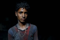 In this Sunday, June 12, 2016, photo, Nizam, 11, looks towards camera as he works at a factory that makes metal utensils in Dhaka, Bangladesh, Sunday, June 12, 2016. He earns less than $5 per week. AP Photo/ A.M. Ahad