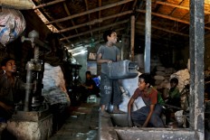 Bangladeshi child laborers share a light moment as they work at a metal factory in  Dhaka, Bangladesh, Sunday, June 12, 2016. The boys earn less than $5 per week. AP Photo/ A.M. Ahad