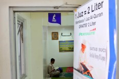 A man recites the Quran at a fuel station on Jl. Abdul Muis in Central Jakarta on June 9. JP/Seto Wardhana.