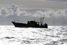 A wooden boat carrying 44 Tamil asylum seekers from Sri Lanka is seen anchored off Aceh's coast on Monday. The Jakarta Post/ Hotli Simanjuntak