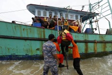 Indonesian rescue team members board the stranded vessel. The Jakarta Post/ Hotli Simanjuntak