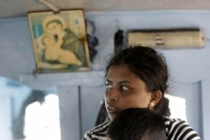 A woman holds her son while they wait for a medical check-up. The Jakarta Post/Hotli Simanjuntak