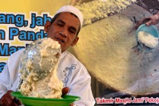 Cook Mad Sa’ad, 72, pours bubur India into a bowl. Bubur India served at the mosque has a uniquely rich flavor thanks to its multifarious spices, such as garlic, onion, ginger, lemongrass, cinnamon, coconut milk and many others. JP/ Albertus Magnus Kus Hendratmo