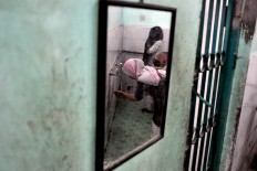 A woman performs the Muslim ritual of washing parts of the body before afternoon prayers. JP/ Albertus Magnus Kus Hendratmo