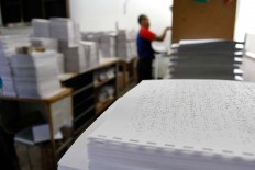 Daul sorts through sheets of paper that have gone through a braille press machine to be bound to make copies of the Quran in braille at the printing house of Penyantun Wyata Guna Foundation in Bandung on June 20. JP/Arya Dipa
