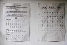 The printing house keeps a guideline for converting Arabic letters into braille on the wall. JP/Arya Dipa