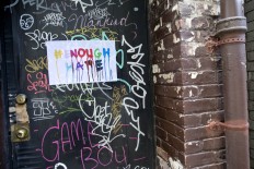 A poster in honor of the victims of the shooting in Orlando is pasted on a graffiti covered doorway on Christopher Street in the Greenwich Village neighborhood of Manhattan, Saturday, June 25, 2016. AP Photo/Mary Altaffer