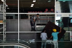 Construction workers repair the damaged walls and windows at the blast site at Ataturk Airport in Istanbul, Wednesday, June 29, 2016. AP Photo/Bram Janssen