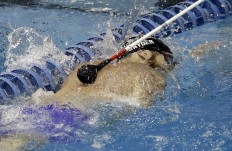 In this Thursday, June 30, 2016 photo, a volunteer taps Brad Snyder to alert him he is approaching the wall for a turn in his 

heat in the men's 400- meter free during the U.S. Paralympics Team Trials in Charlotte, N.C. Snyder, a Navy veteran, was 

blinded after he stepped on an improvised explosive device in Afghanistan in 2011. AP Photo/Chuck Burton