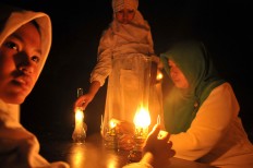 Students light the oil lamps before heading outdoor for the recital event. JP/ Ganug Nugroho Adi