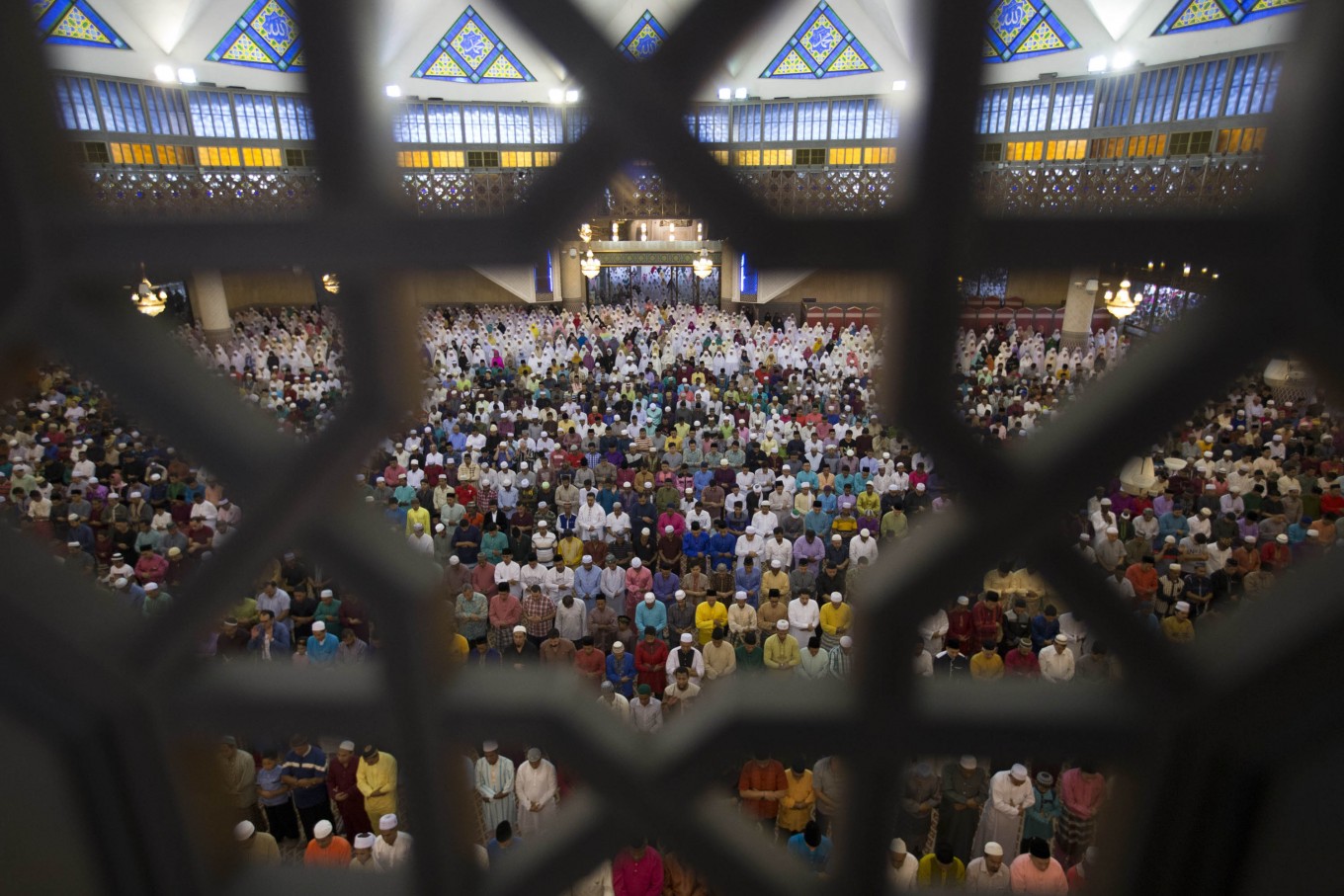 Muslims pray during morning prayer for Eid al-Fitr, marking the end of the holy month of Ramadan, at the National Mosque in Kuala Lumpur, Malaysia, Wednesday, July 6, 2016. AP Photo/Vincent Thian